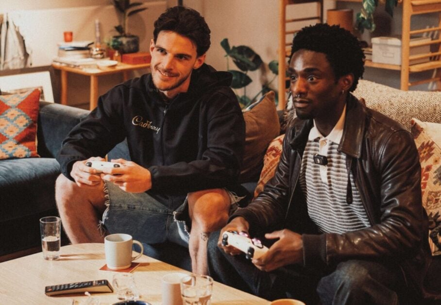 Declan Rice gaming with a fan while wearing Cadbury-branded clothing
